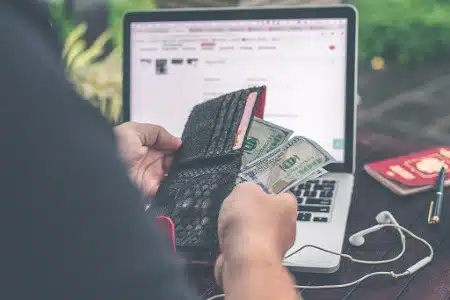 person holding wallet and money