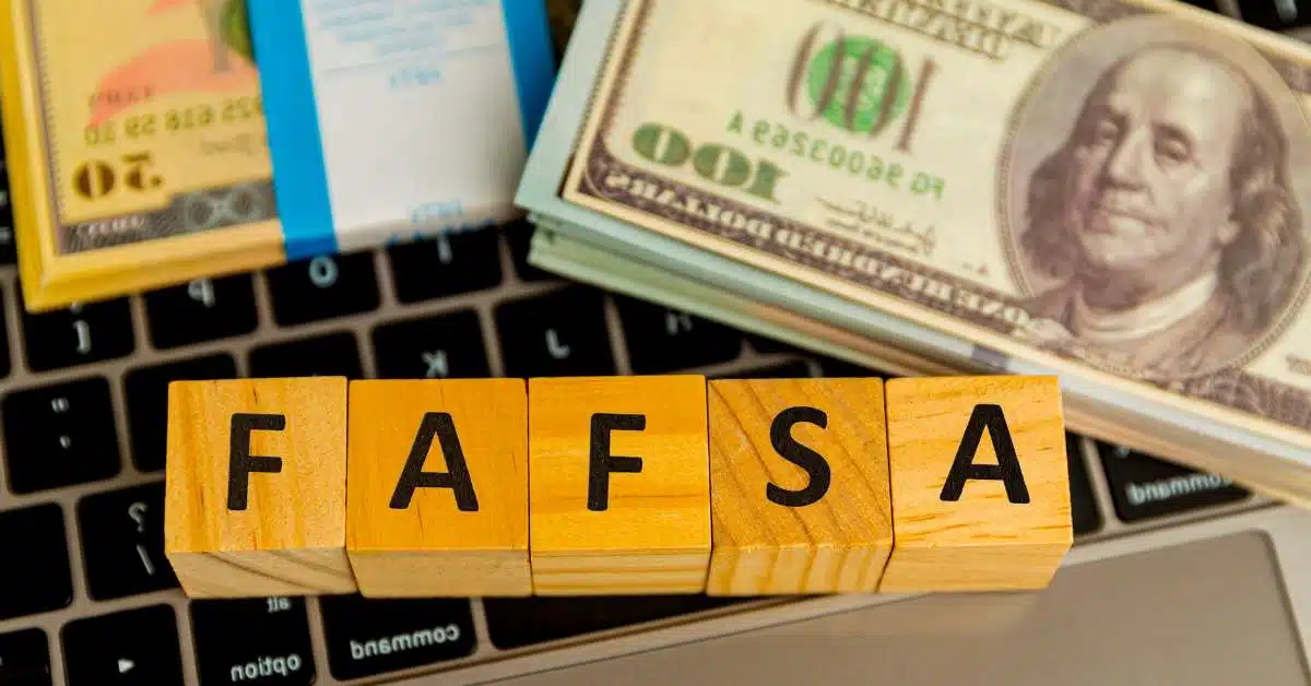 Money and blocks spelling out "FAFSA" sitting on a keyboard
