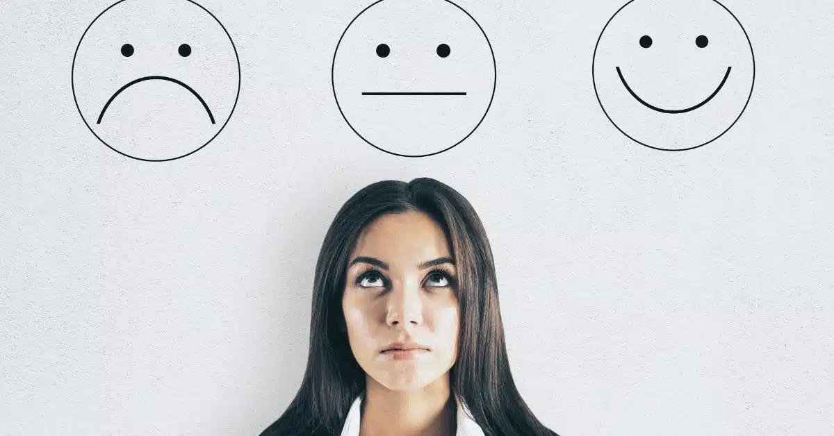 A frowny face, straight face, and smiley face with a woman standing under the straight face and looking up with an unhappy look