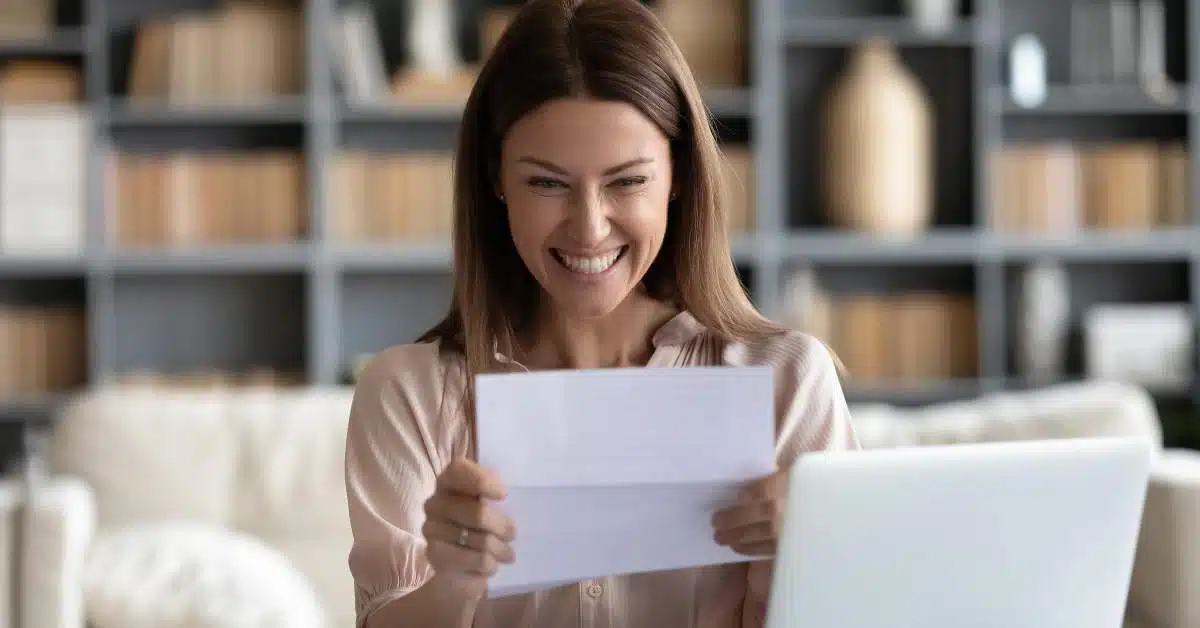 Young woman excitedly reading a scholarship offer