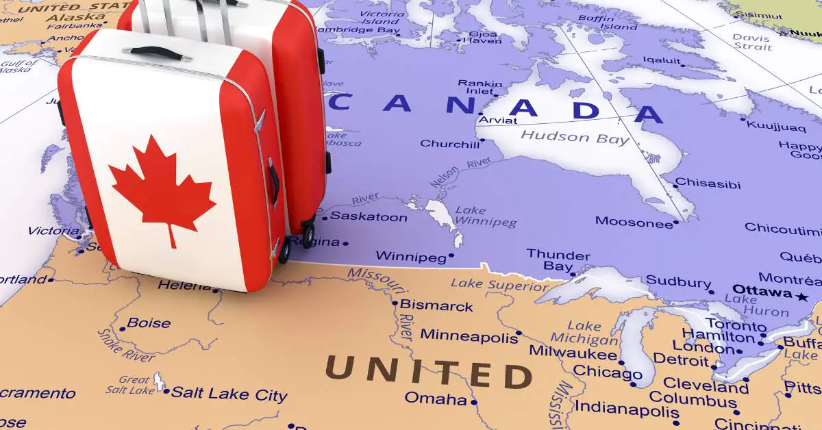 Picture of a map of the United States and Canada with two suitcases with Canadian flags sitting on the maps.