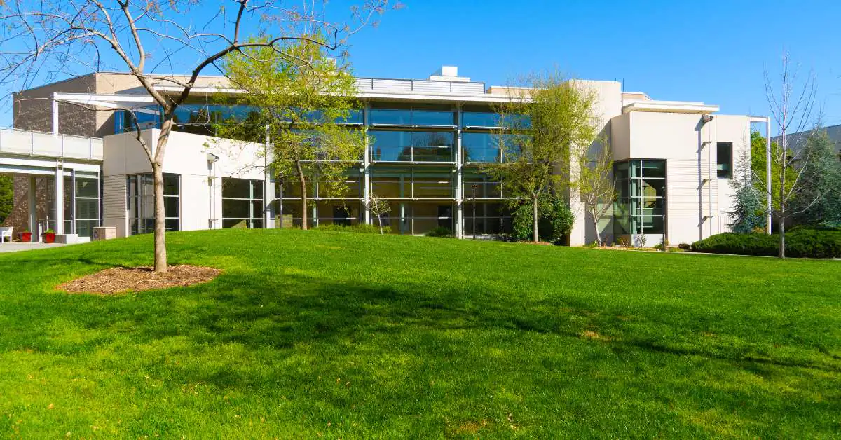 White building with large windows looking over a grassy lawn at the University of California, Davis
