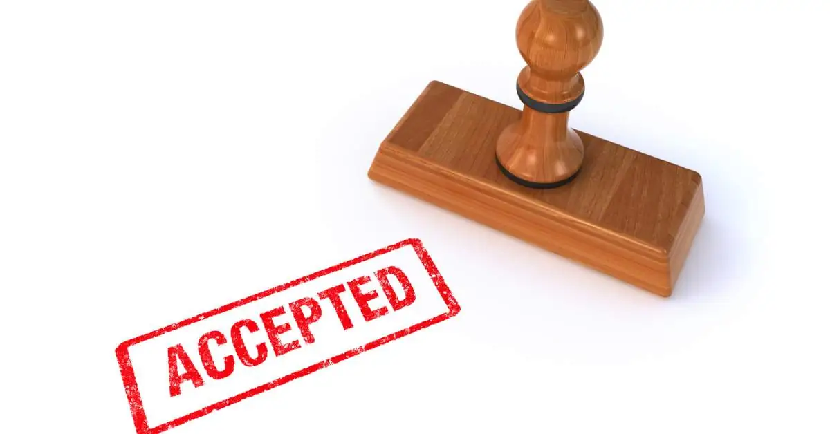 A stamper on one side and the word "Accepted" stamped in red on a white sheet of paper.